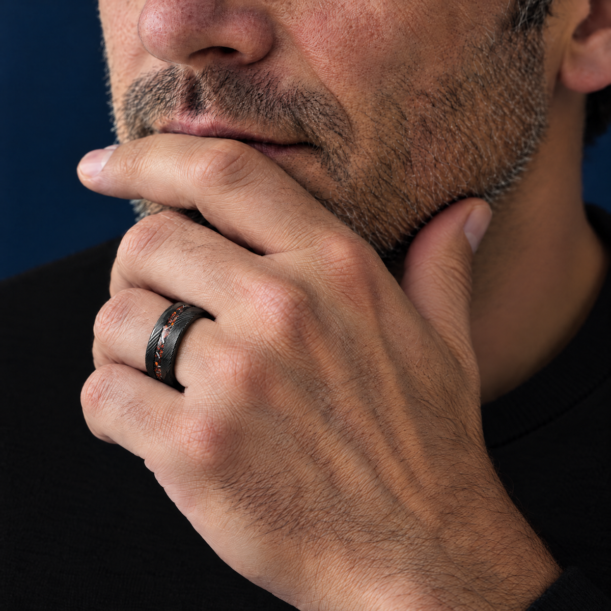 The Fathom black Damascus tungsten ring with meteorite and bone inlay worn on the left hand
