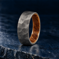 The Cooper hammered titanium ring with whiskey barrel oak interior, angled view
