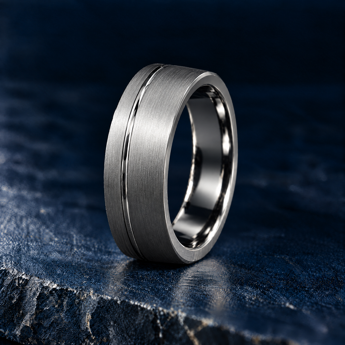 The Furrow silver tungsten ring, brushed finish with offset polished groove, angled view